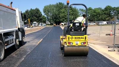 surface dressing and tarmac on road surfacing being rollered into place