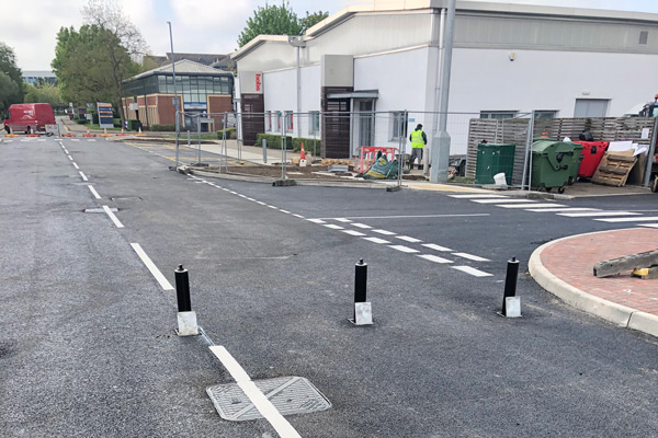 road surfacing of access road into industrial estate blocked by bollards